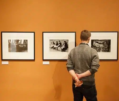 comment accrocher un cadre comme un pro-une personne regarde 3 cadres photos parfaitement accrochés dans un musée